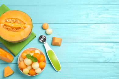 Photo of Melon balls and mint in bowl on light blue table, flat lay. Space for text