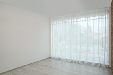 Empty room with white wall and large window