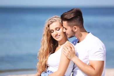 Happy young couple at beach on sunny day