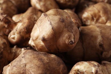 Photo of Many fresh Jerusalem artichokes as background, closeup