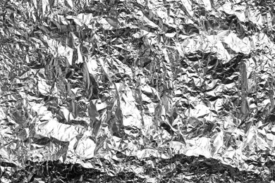 Photo of Crumpled silver foil as background, closeup view