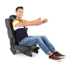 Young man sitting in car seat with safety belt on white background