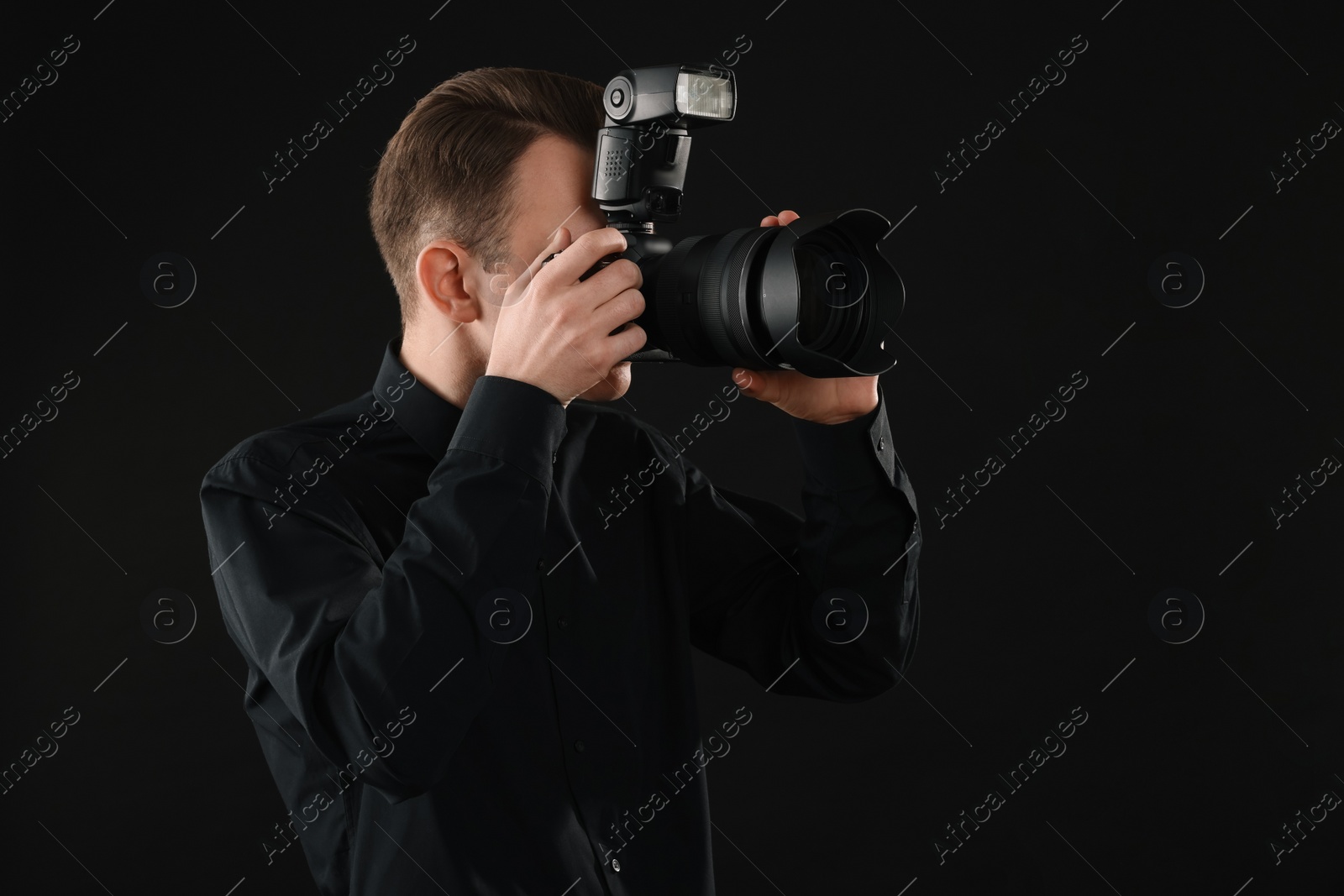 Photo of Professional photographer taking picture on black background