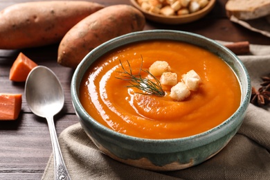 Bowl of tasty sweet potato soup served on table