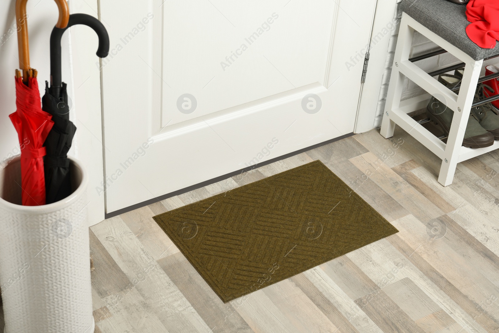 Photo of Clean door mat on wooden floor in hall