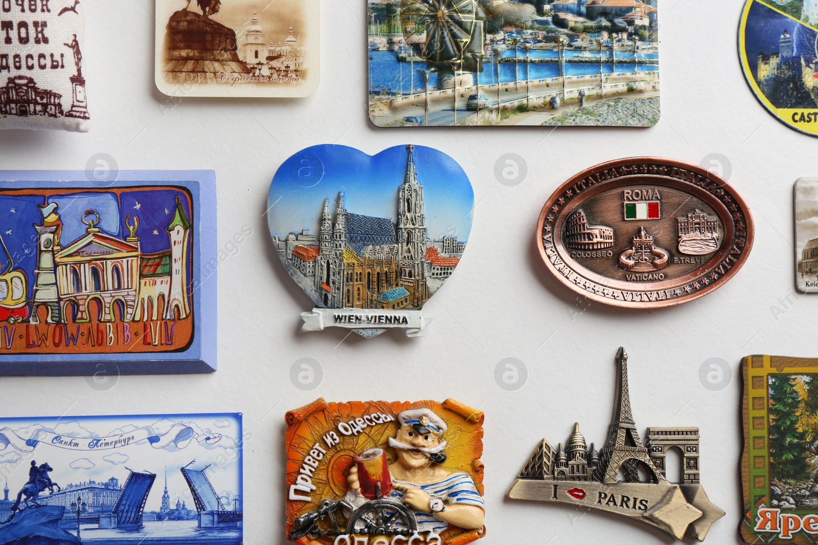 Photo of MYKOLAIV, UKRAINE - DECEMBER 25, 2018: Many different souvenir magnets on white background, flat lay