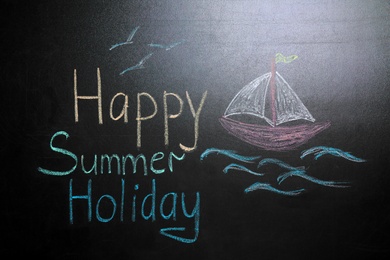 Photo of Inscription Happy Summer Holiday and drawing of boat on blackboard. School break