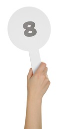 Woman holding auction paddle with number 8 on white background, closeup