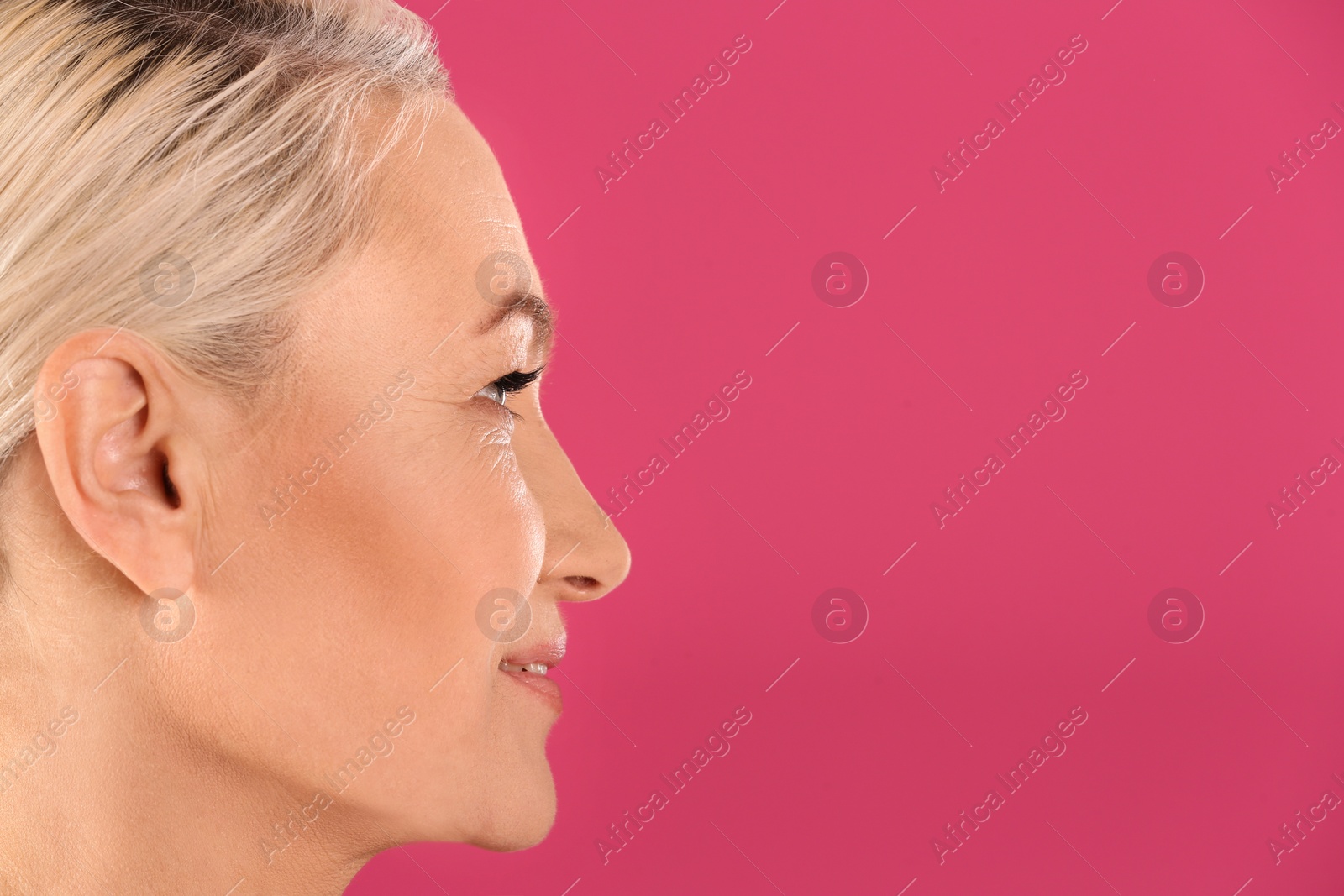 Photo of Portrait of beautiful mature woman on pink background, closeup. Space for text