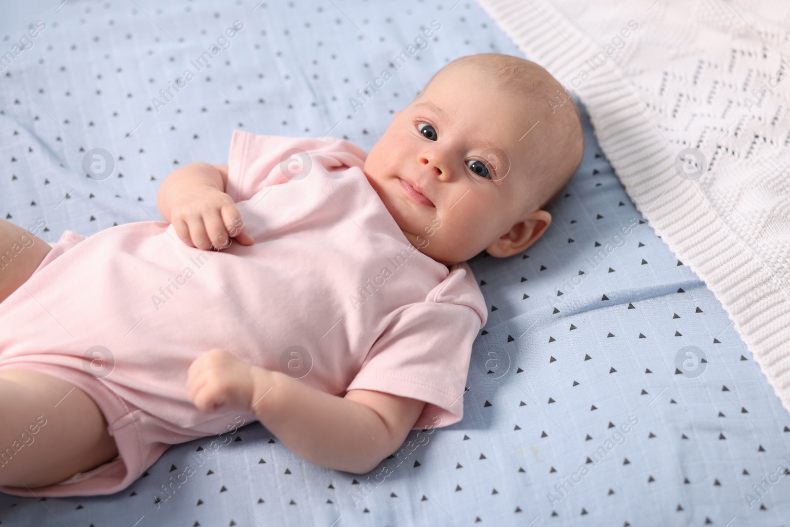 Photo of Cute little baby lying in crib at home