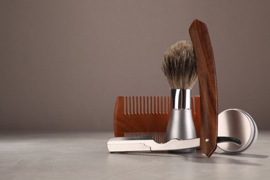 Moustache and beard styling tools on grey table. Space for text