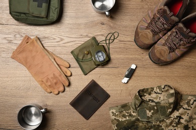 Flat lay composition with camping equipment on wooden background