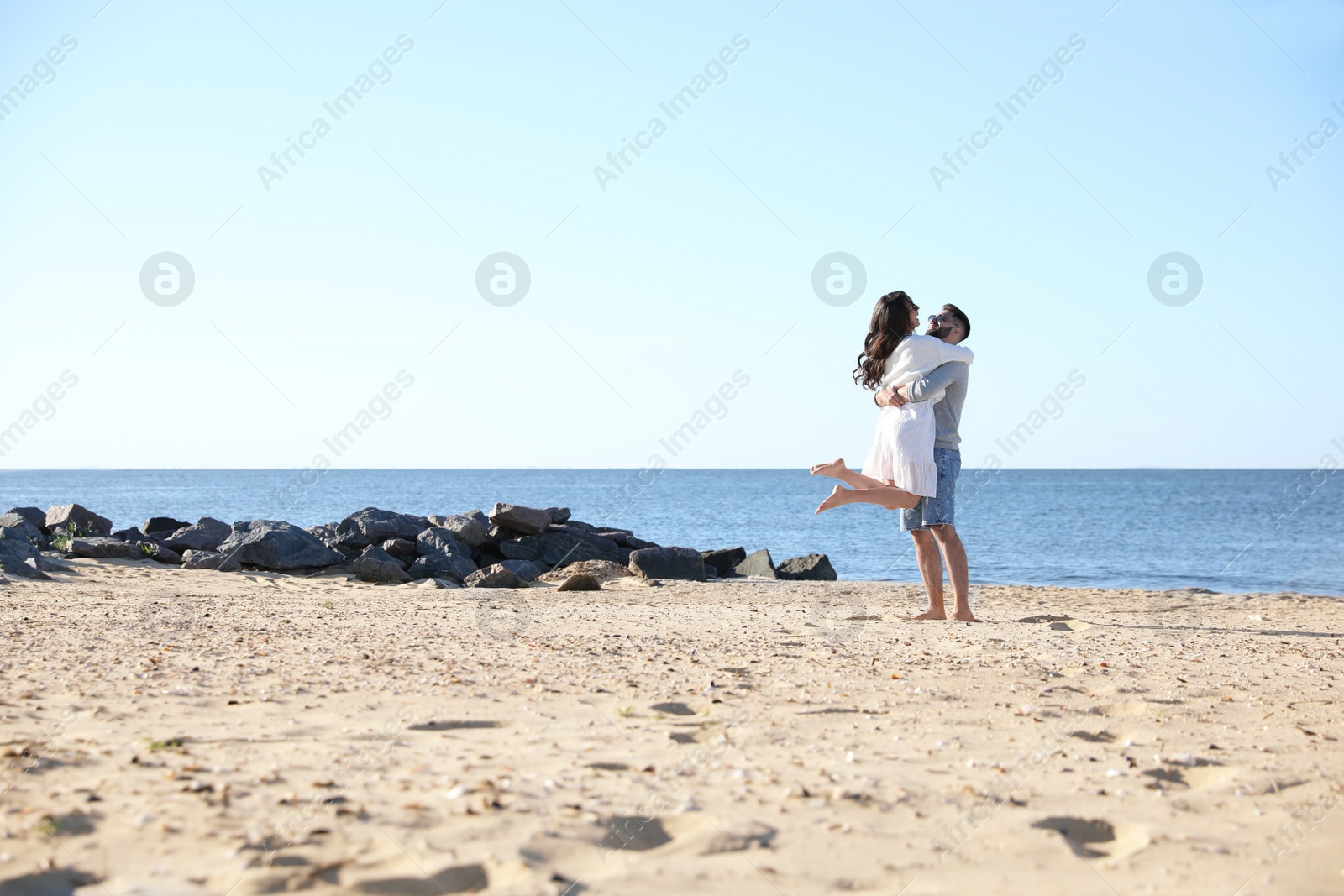 Photo of Happy young couple on beach near sea. Honeymoon trip