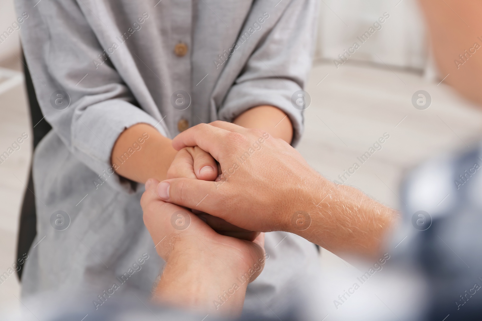 Photo of Man holding woman's hands indoors, closeup. Concept of support and help