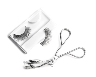 Photo of Curler and false eyelashes on white background