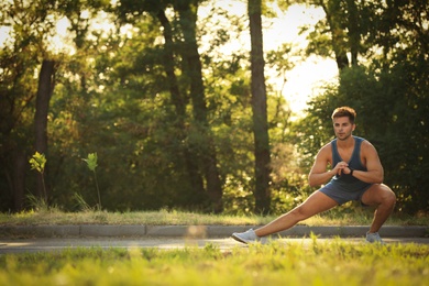 Photo of Young man doing exercise in park on sunny day