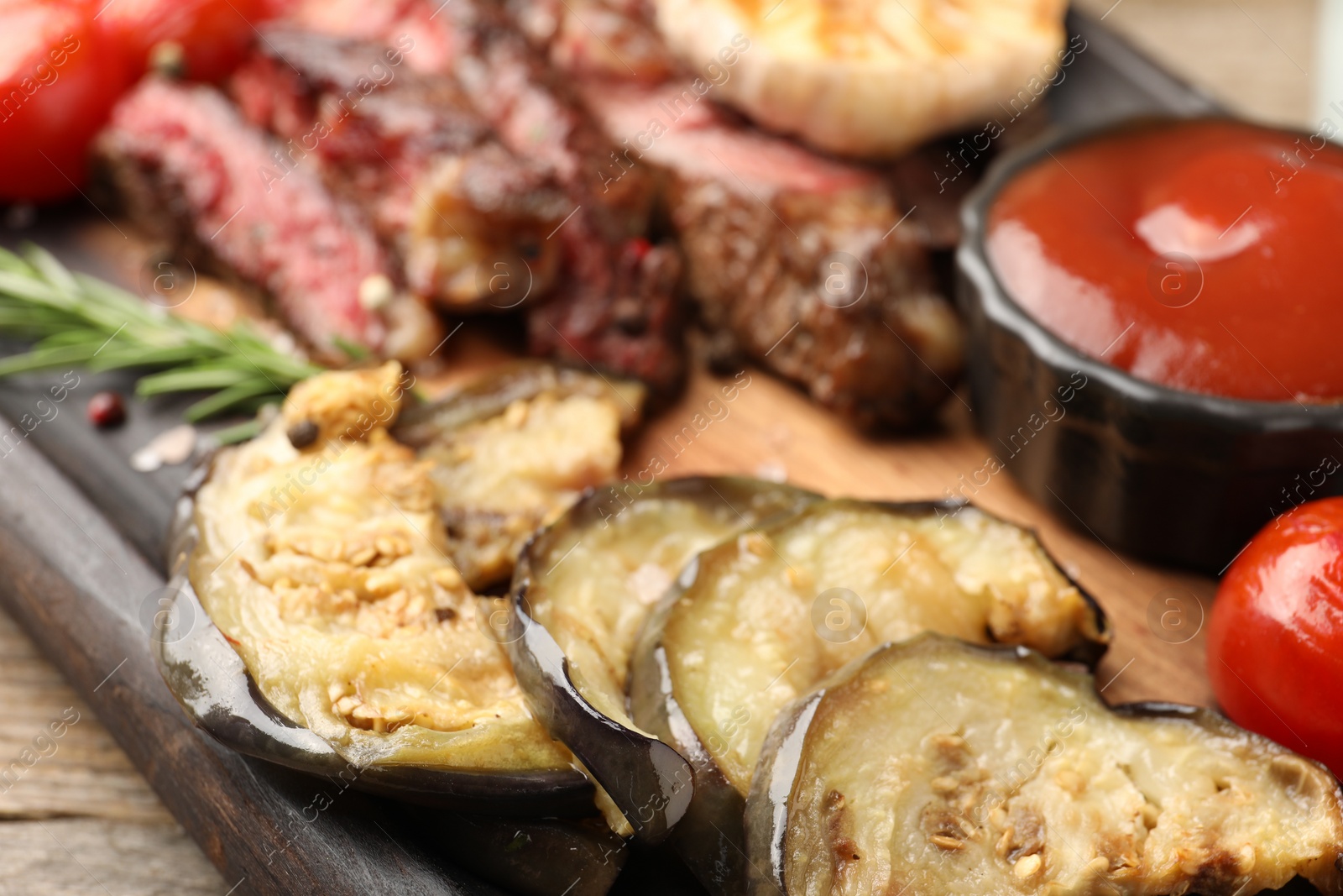 Photo of Delicious grilled vegetables, beef with spices and tomato sauce on table, closeup