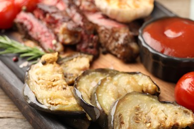 Delicious grilled vegetables, beef with spices and tomato sauce on table, closeup