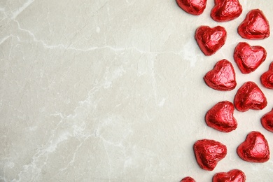 Heart shaped chocolate candies on light grey table, flat lay with space for text. Valentine's day treat