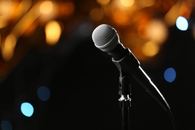 Photo of Microphone against festive lights, space for text. Musical equipment