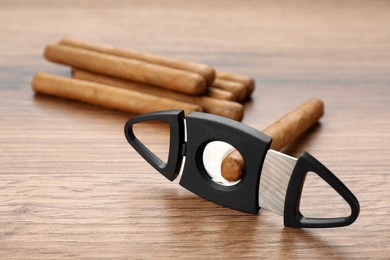 Cigars and guillotine cutter on wooden table