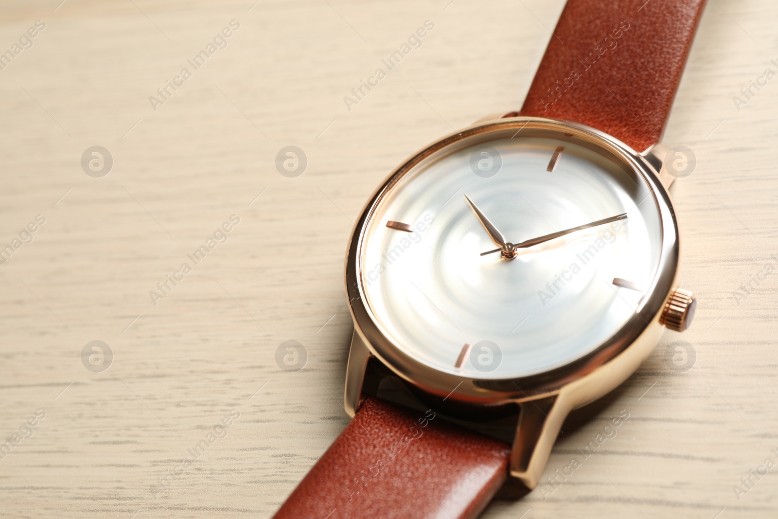 Photo of Luxury wrist watch on wooden background, closeup. Space for text