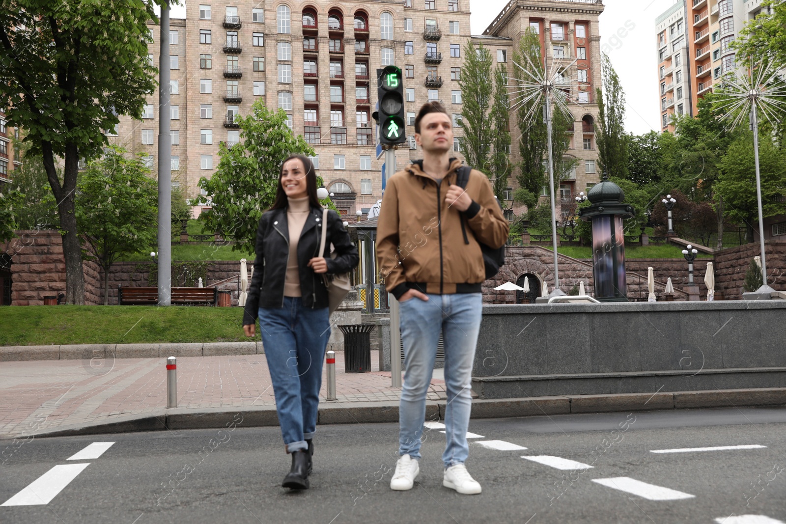 Photo of Young people crossing street at traffic lights