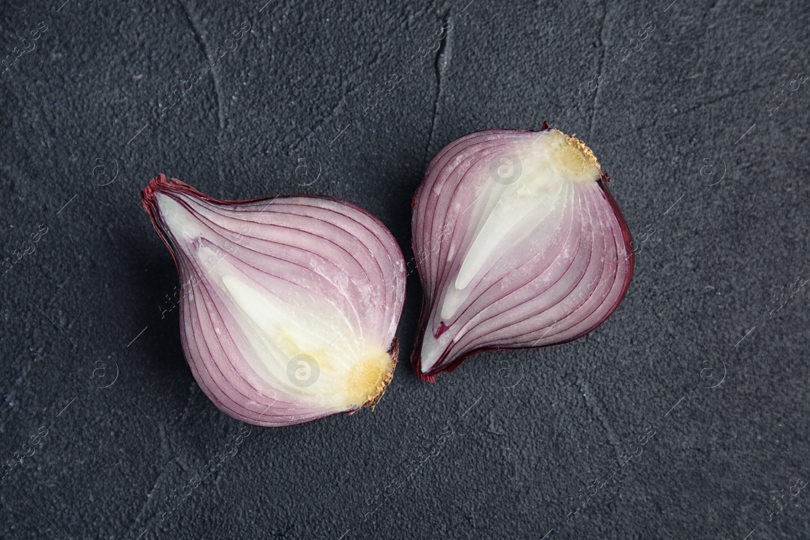 Photo of Ripe cut red onion on dark background, top view