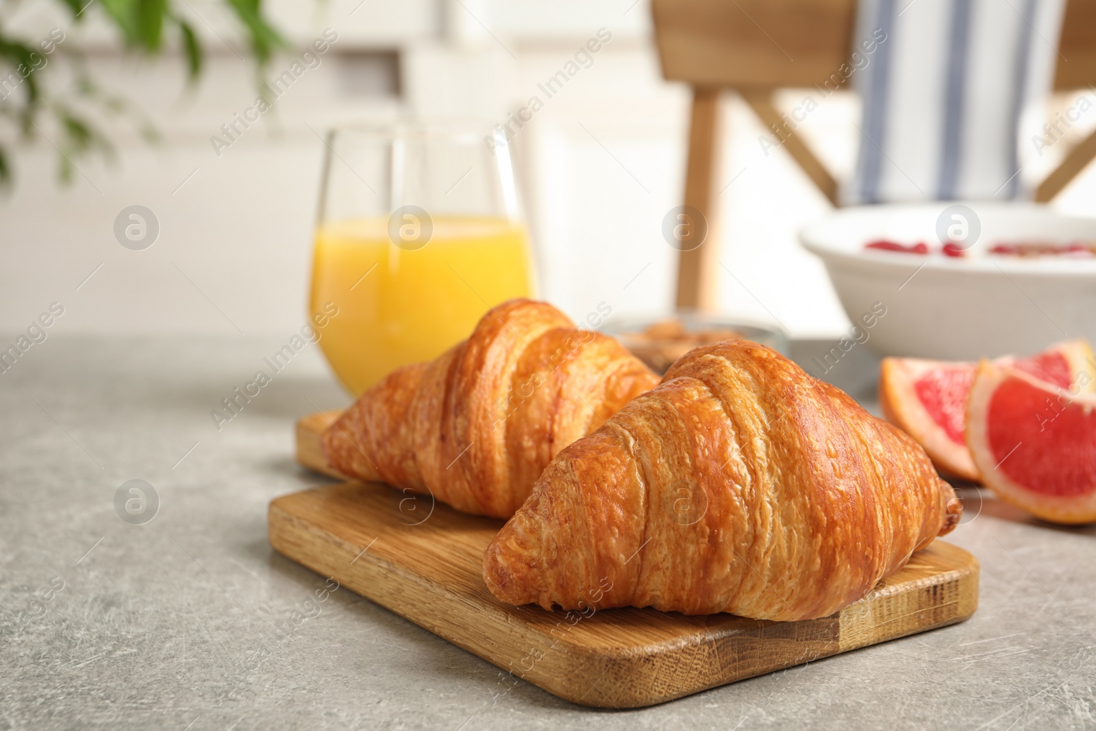 Photo of Tasty fresh croissants on light grey table. Healthy breakfast