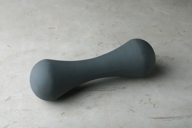 Photo of Grey rubber coated dumbbell on light table