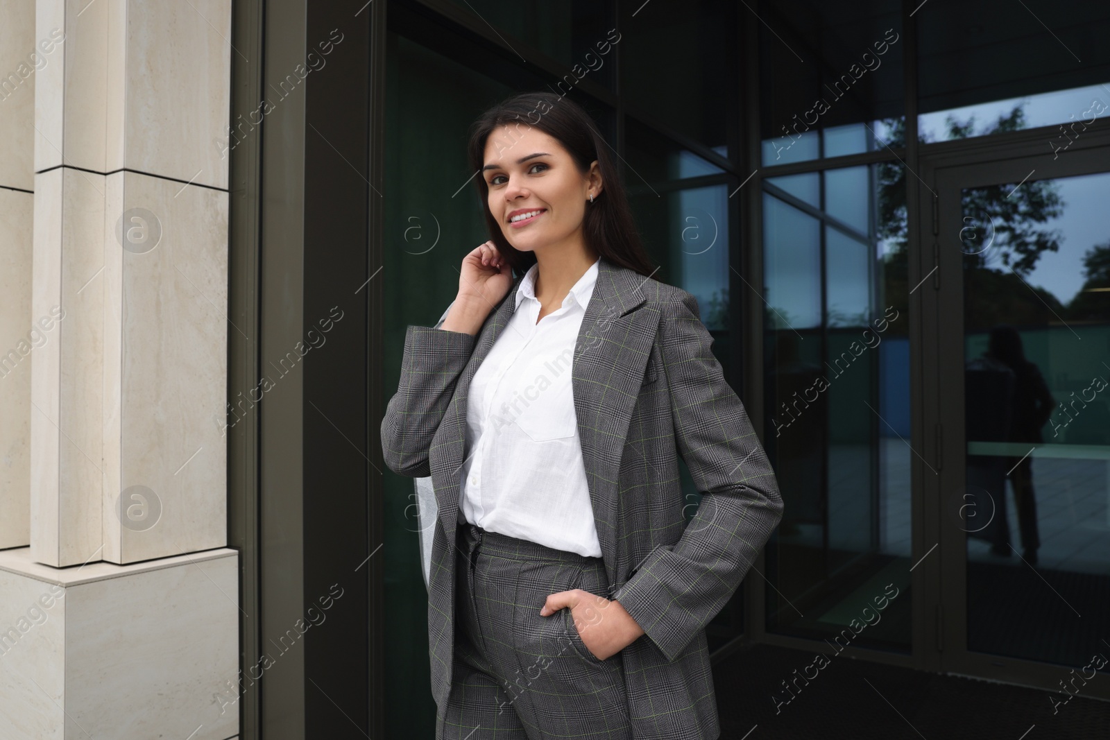 Photo of Attractive happy businesswoman holding garment cover with clothes outdoors. Dry cleaning service