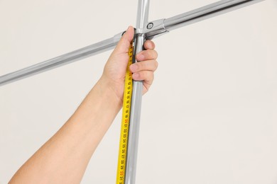 Worker measuring metal pipes for installation, closeup