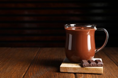 Photo of Cup of delicious hot chocolate on wooden table, space for text