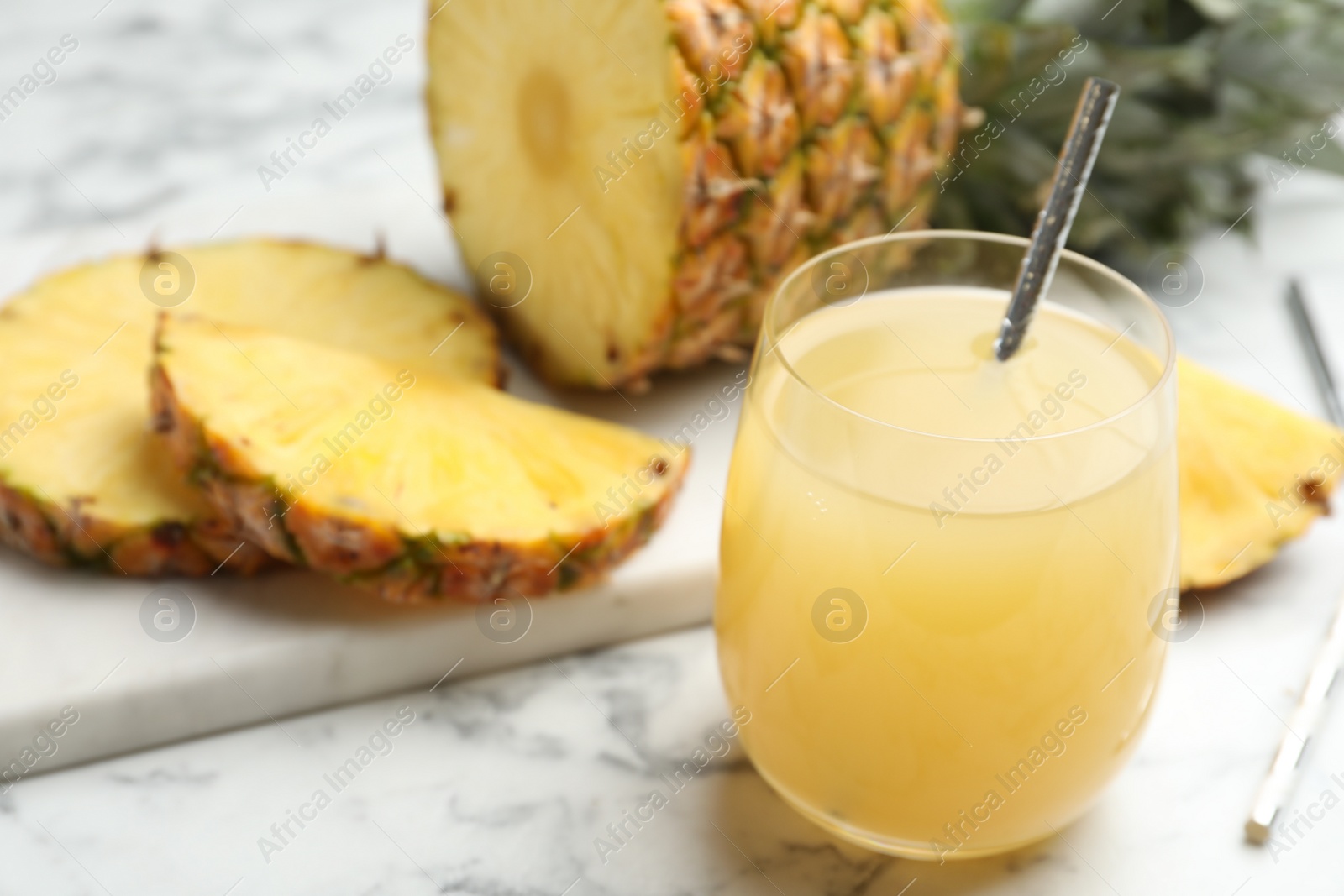 Photo of Delicious fresh pineapple juice on white marble table