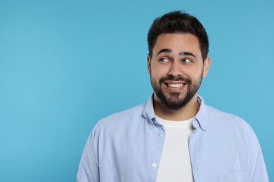 Embarrassed man on light blue background. Space for text