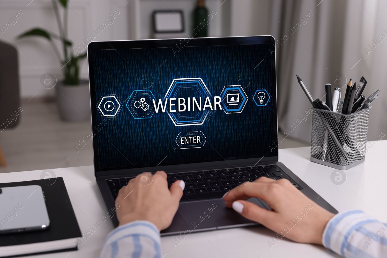 Image of Online webinar, web page on computer screen. Woman using laptop at white table, closeup