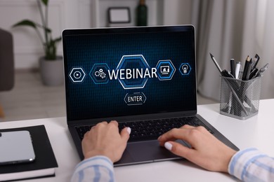 Online webinar, web page on computer screen. Woman using laptop at white table, closeup