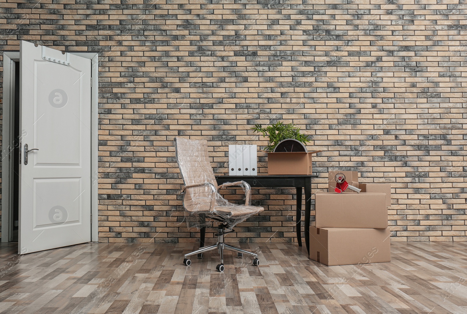 Photo of Furniture and moving boxes in empty office