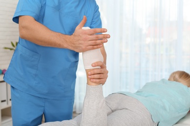 Photo of Physiotherapist working with patient in clinic. Rehabilitation therapy