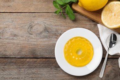 Photo of Delicious fresh yellow jelly on wooden table, flat lay. Space for text