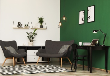 Modern living room interior with workplace near green wall