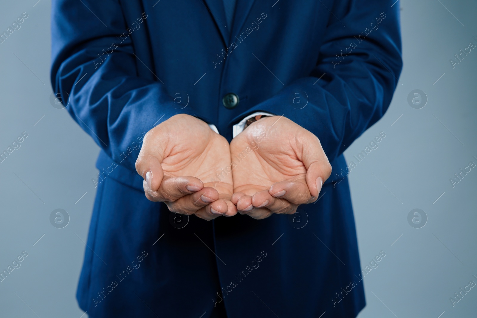 Photo of Businessman holding something on grey background, closeup of hands