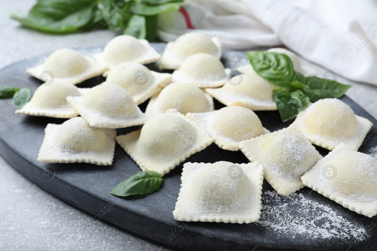 Photo of Homemade uncooked ravioli on board, closeup view