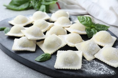 Photo of Homemade uncooked ravioli on board, closeup view