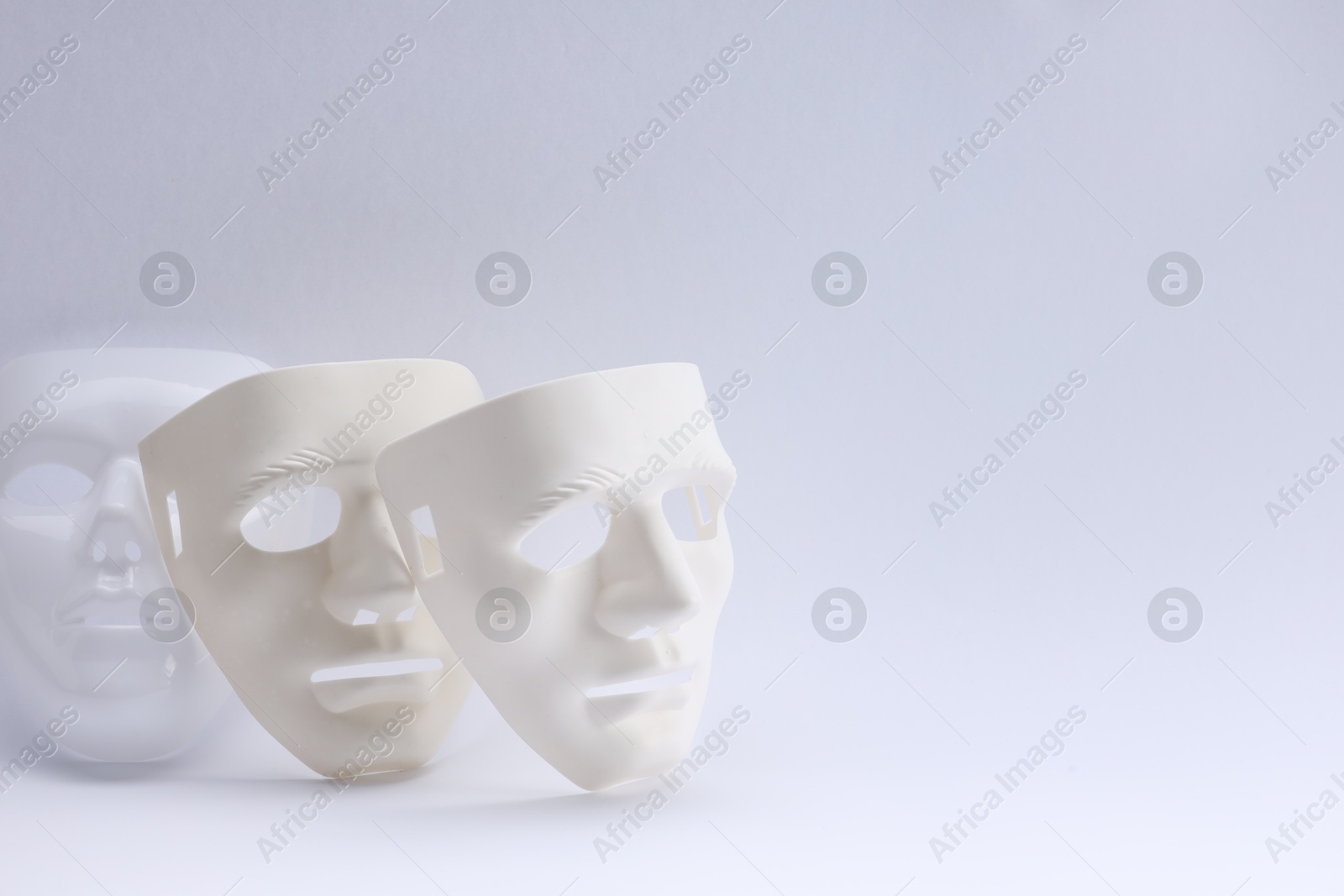 Photo of Plastic face masks on white background, space for text. Theatrical performance