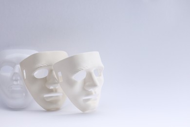 Plastic face masks on white background, space for text. Theatrical performance