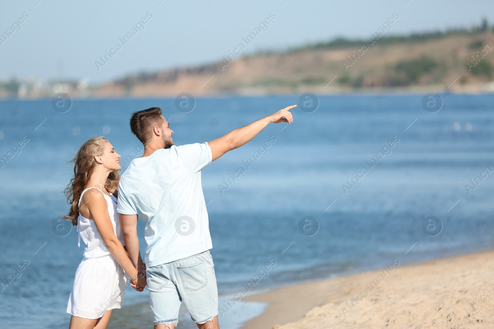 Photo of Happy young couple at beach on sunny day