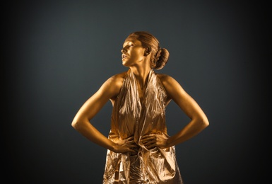 Photo of Portrait of beautiful lady with gold paint on skin against grey background