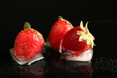 Photo of Frozen strawberries on dark table. Keeping fruits fresh