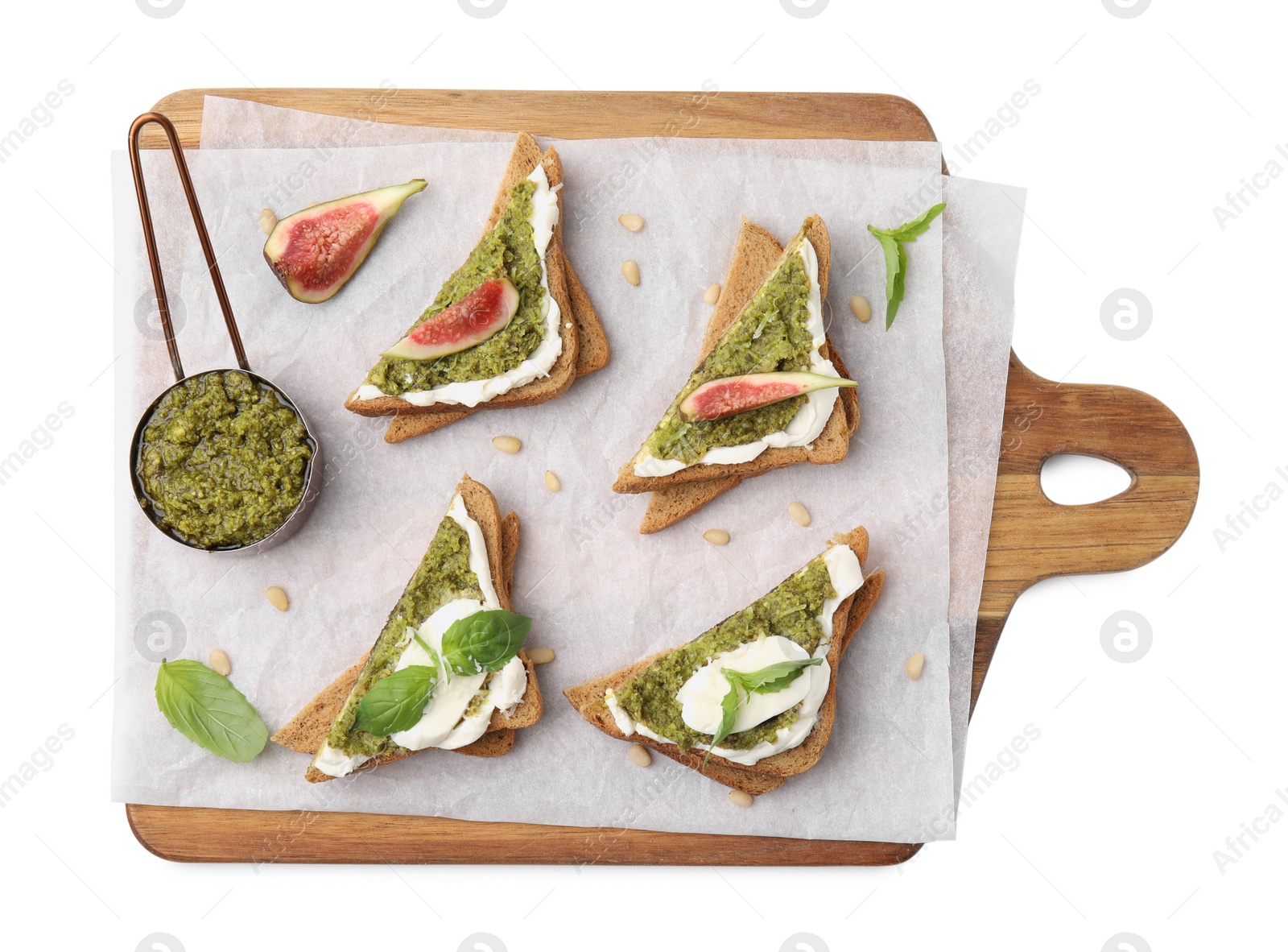 Photo of Tasty bruschettas with cream cheese, pesto sauce and fresh basil on white background, top view